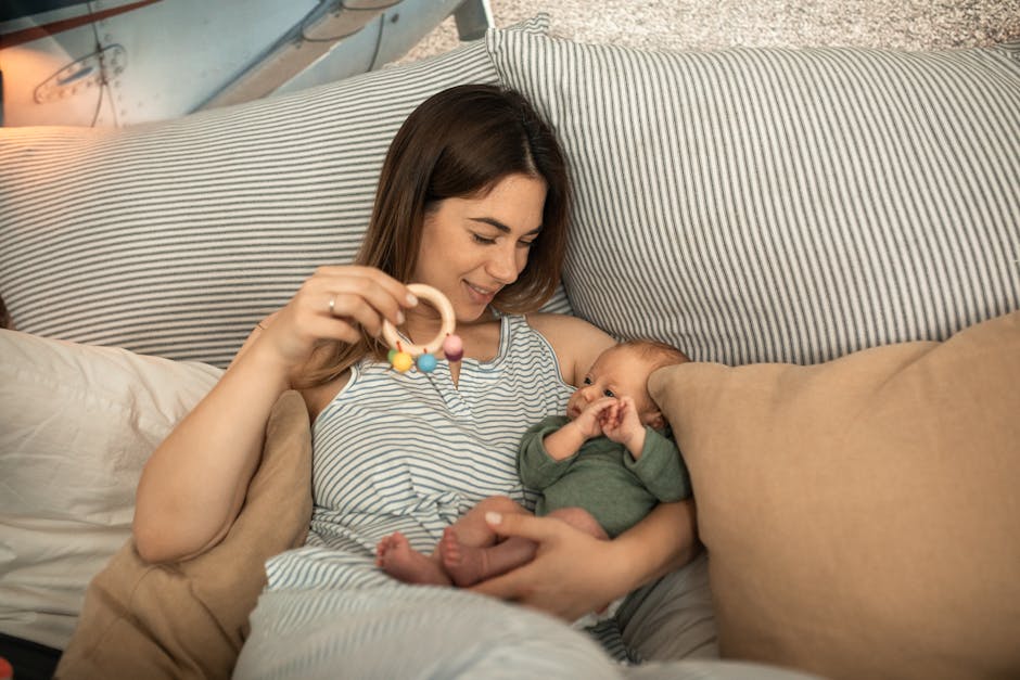 pexels photo 6849556 6849556 A mother joyfully playing with her newborn baby in a warm, cozy bedroom setting.